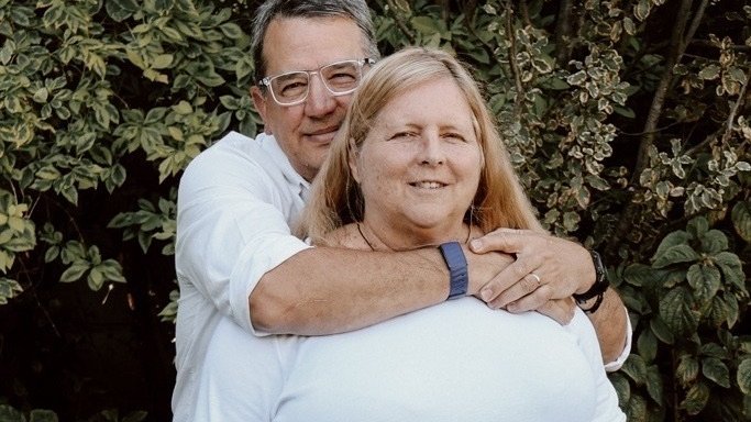 Dementia advocate Stuart with his arms around his wife Bridget
